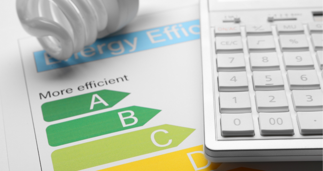 Energy efficiency rating chart fluorescent light bulb and calculator closeup.