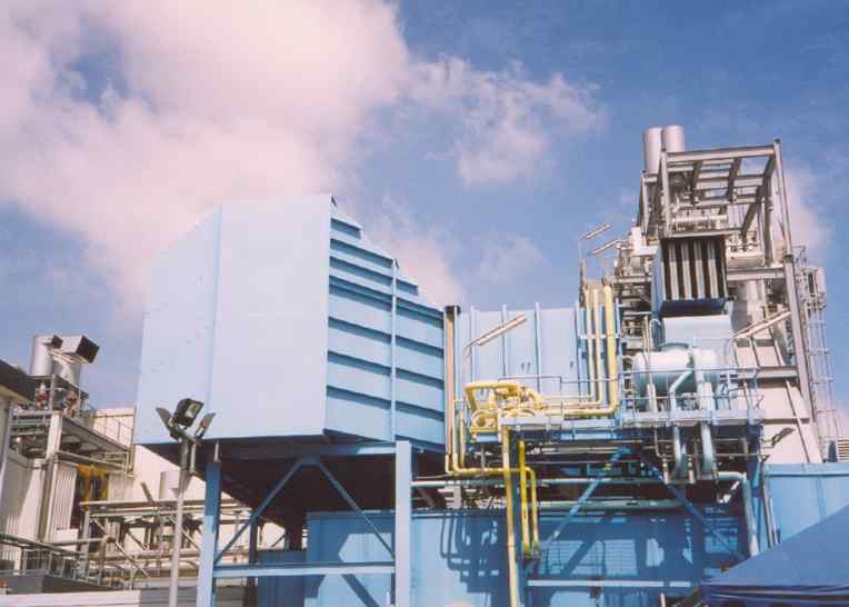 Industrial machinery with blue structures and yellow pipes against a cloudy sky, showcasing modern engineering and design.