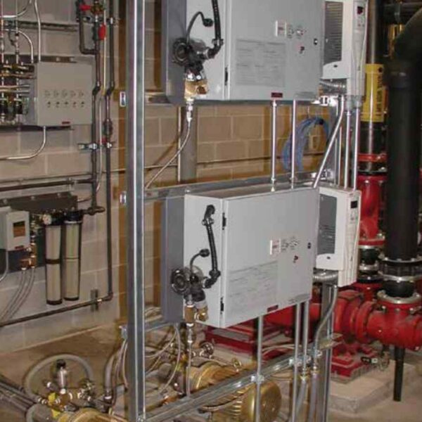Industrial pump system featuring stacked motor-driven pumps and control panels, with pipes and valves connected to a network of equipment.