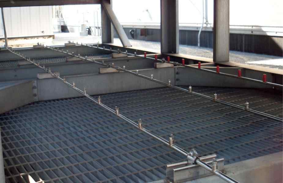 Close-up of a metal structure featuring grid flooring and horizontal support rods, used in industrial applications or facilities.