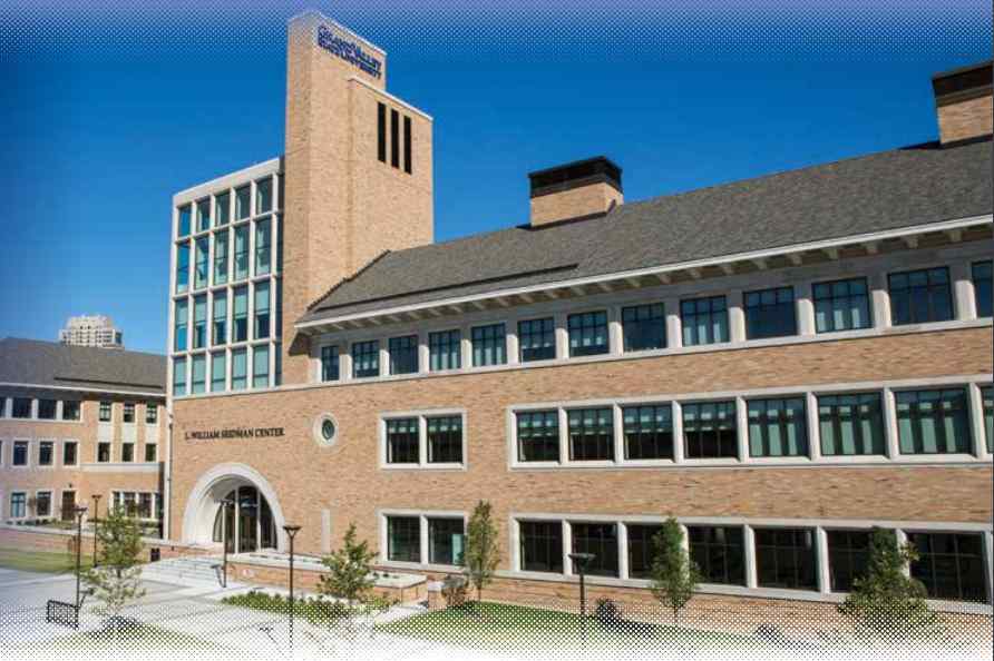 The L. William Seidman Center, a modern brick building with large windows, set against a clear blue sky.