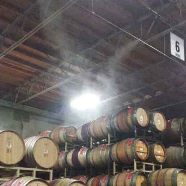 Row of stacked wooden barrels in a dimly lit warehouse, with steam rising near a bright light and the number 6 visible above.