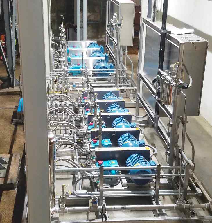 A view of multiple blue motors connected to pipes and valves, forming an intricate industrial water system setup.