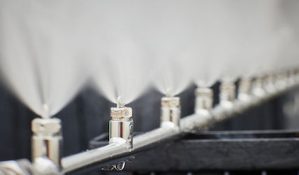 A series of MeeFog Impaction Pin Nozzles mounted on a high-pressure manifold, producing ultra-fine water droplets.