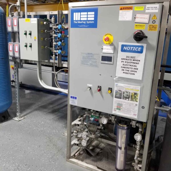 Control panel for the MeeFog system, featuring gauges, valves, and safety notices in an industrial setting.