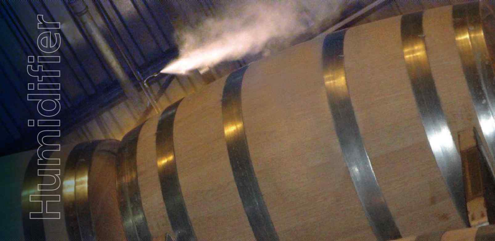 A steam humidifier emits vapor above a wooden barrel with metallic bands, enhancing moisture in the environment.
